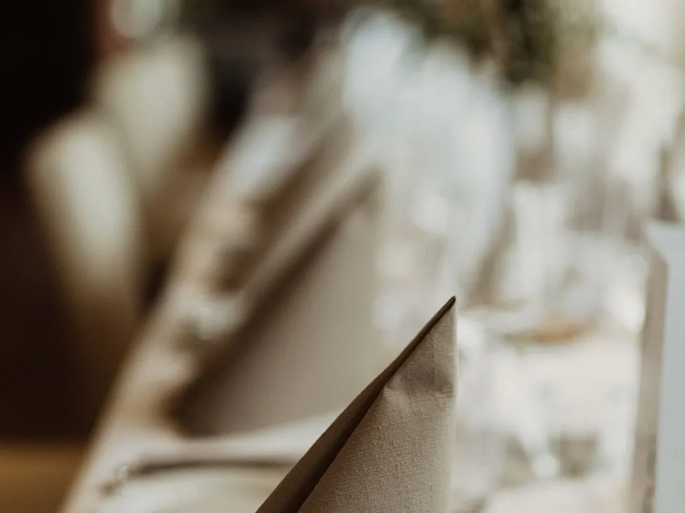 Serviette de table en tissu soigneusement pliée sur une table dressée